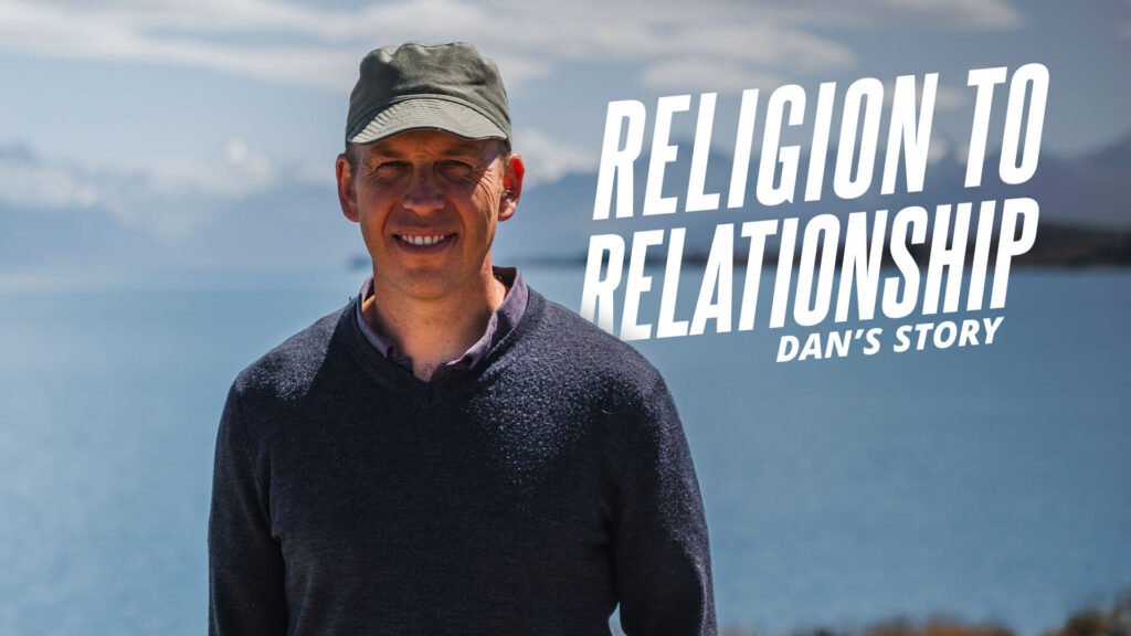 Religion to Relationship Dan's Story. A man smiles with Lake Tekapo in New Zealand in the background.